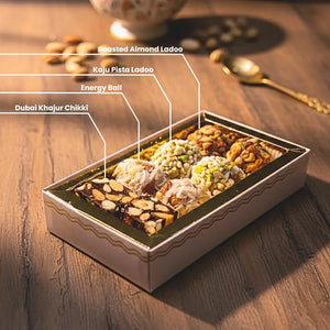 An assortment of Roasted Almond Ladoo, Kaju Pista Ladoo, Energy Balls, and Dubai Khajur Chikki from the best sweet shop in Surat.