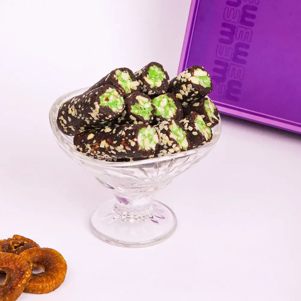 Anjir Pista Roll pieces on a wooden platter, a popular choice for sugar free sweets Surat and healthy gifting.